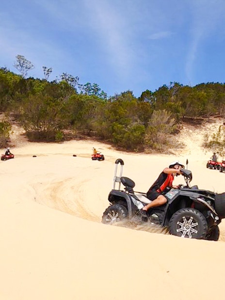 ATV riders navigate sandy dunes at Tangalooma Island Resort.
