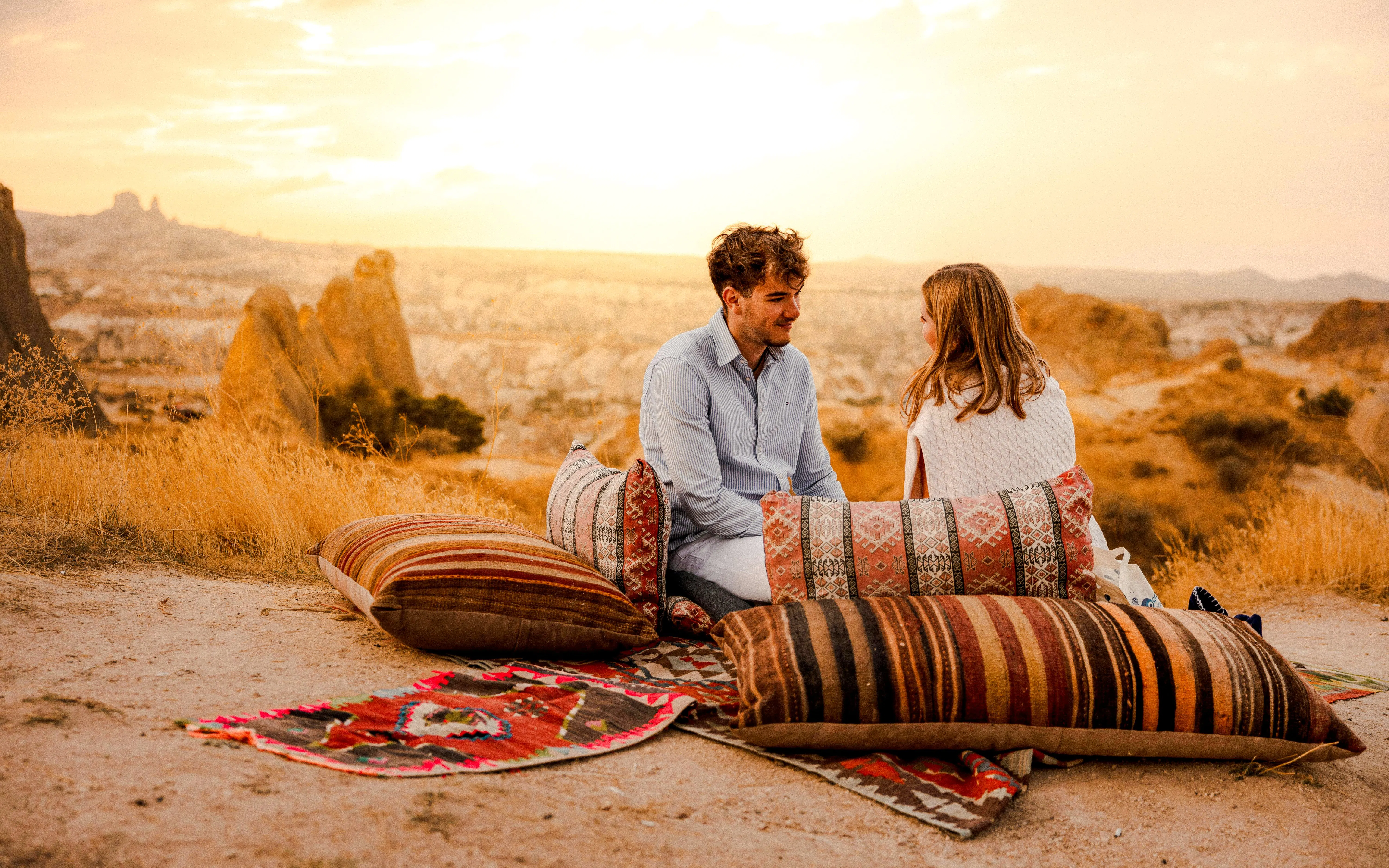 Couple enjoying a private sunset picnic in Cappadocia with scenic rock formations.