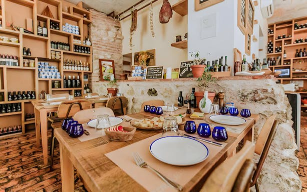 Wine tasting setup in a rustic room at Diocletian's Palace, Split, with bottles and snacks.
