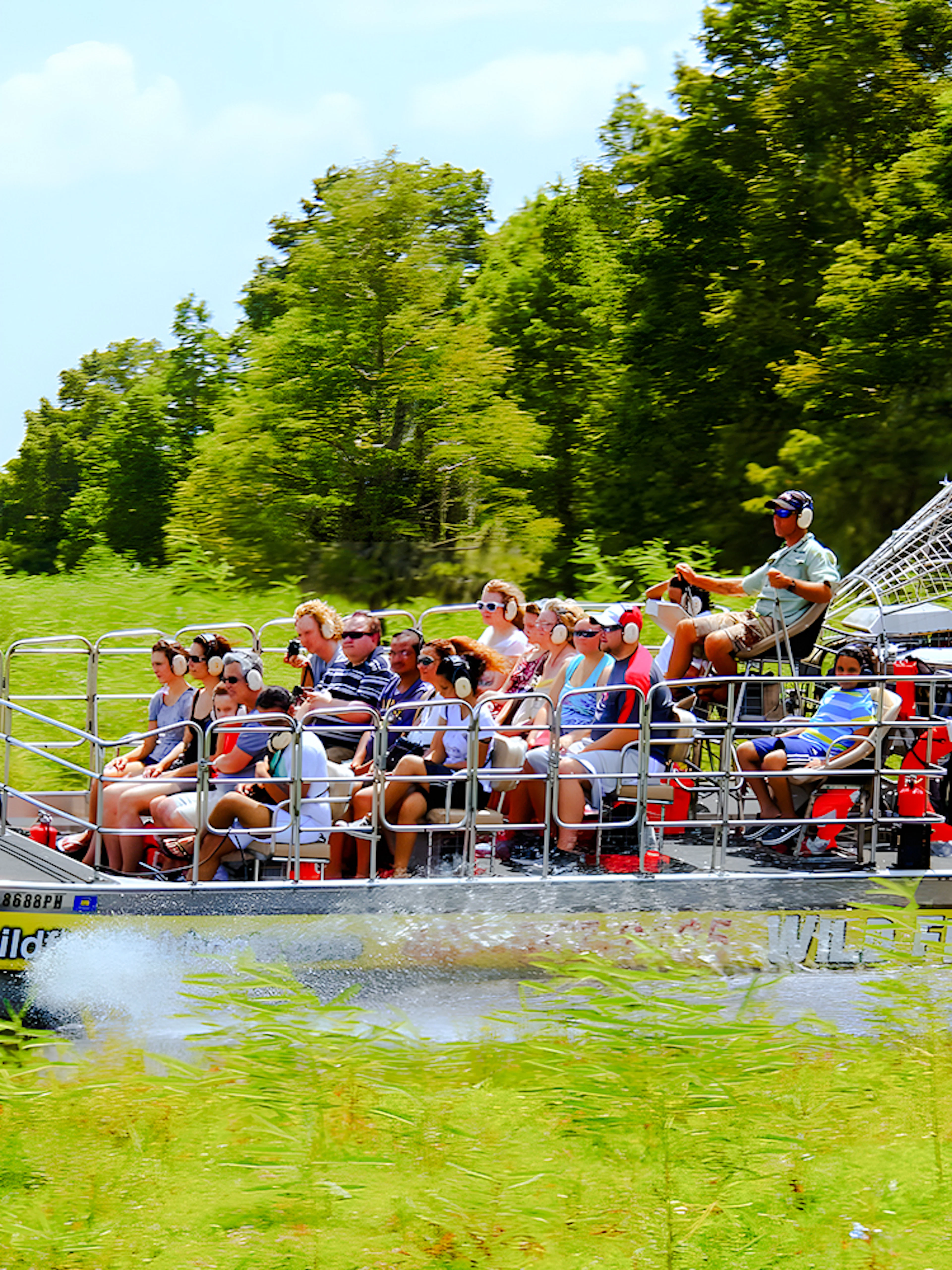 People riding an airboat through the Everglades, Florida.