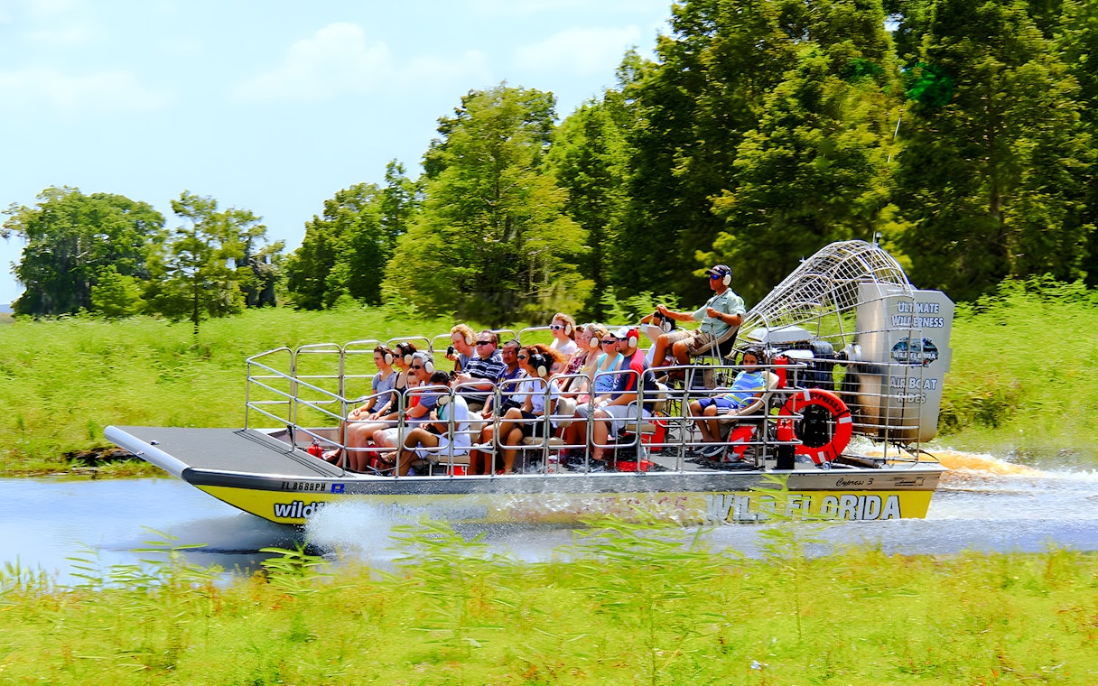 People riding an airboat through the Everglades, Florida.