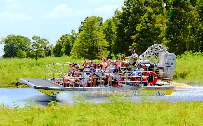 People riding an airboat through the Everglades, Florida.