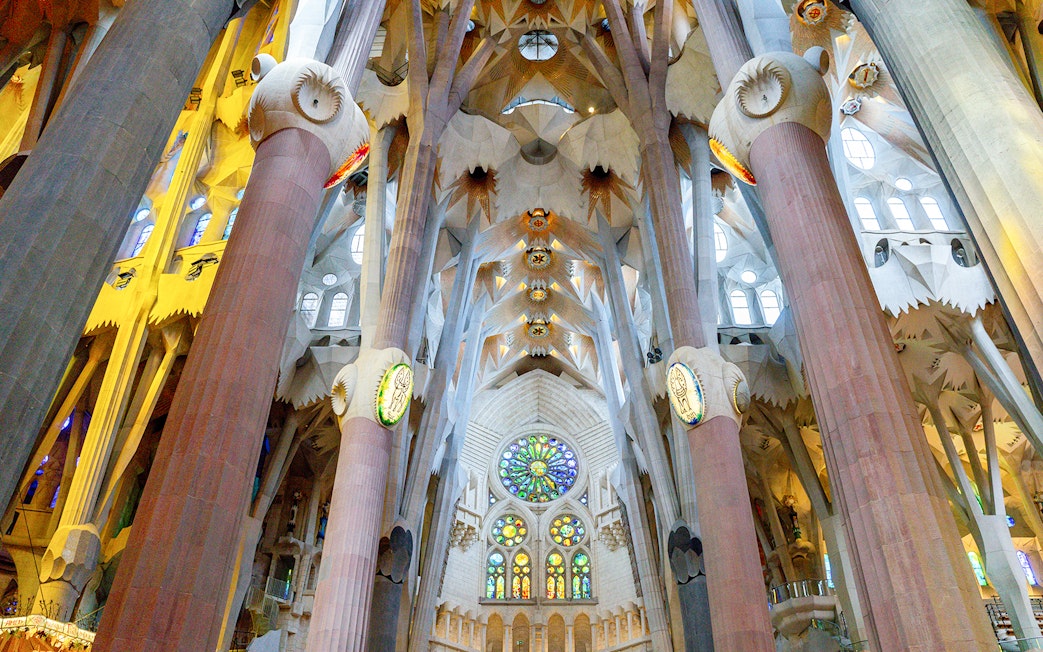 Sagrada Familia interior with stained glass windows and ornate columns in Barcelona.