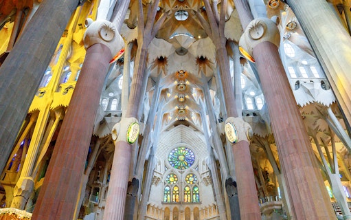 Sagrada Familia interior with stained glass windows and ornate columns in Barcelona.