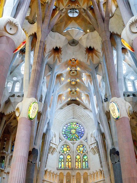 Sagrada Familia interior with stained glass windows and ornate columns in Barcelona.
