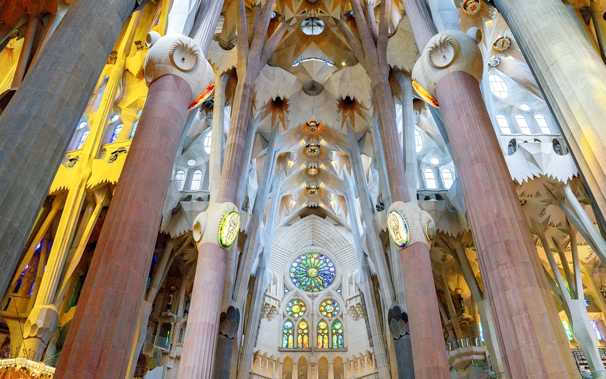 Sagrada Familia interior with stained glass windows and ornate columns in Barcelona.