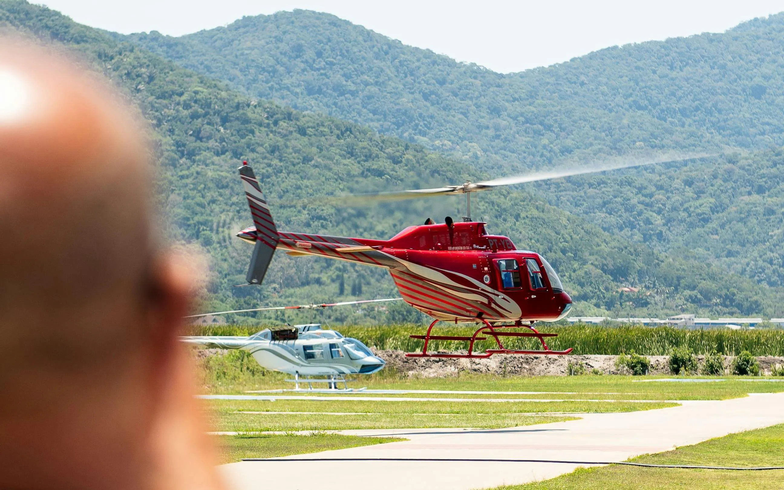 Helicopter taking off for tour in Rio de Janeiro with mountains in background.