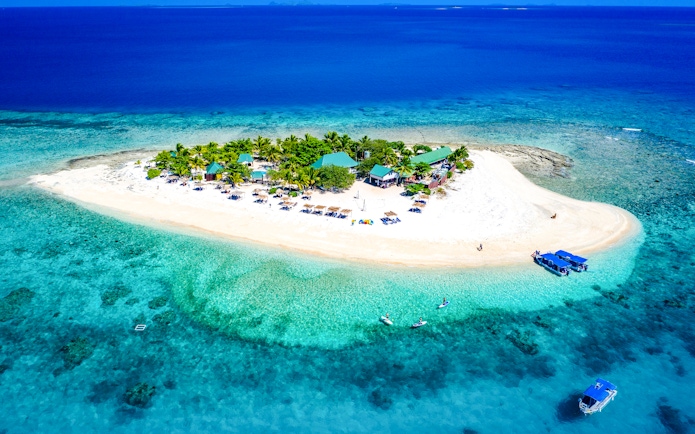 Panoramic aerial view of South Sea Island, Fiji, with clear turquoise waters and sandy beaches.
