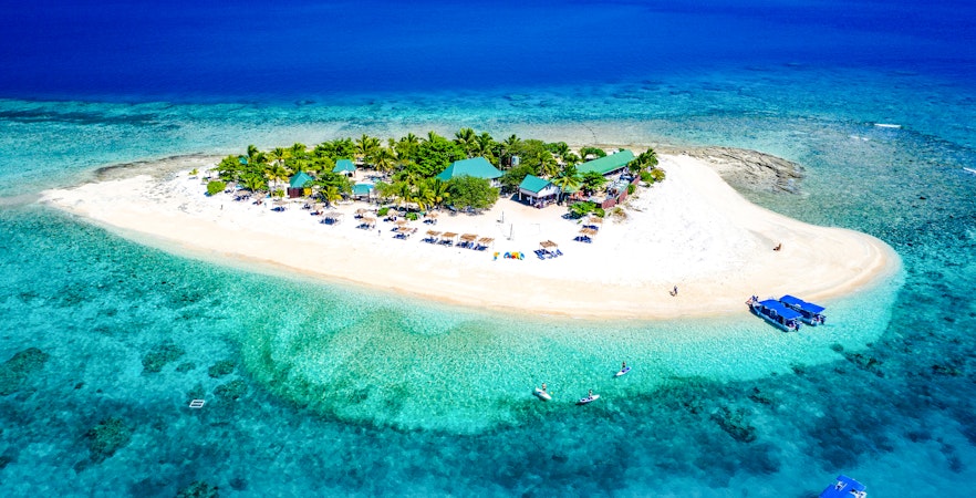 Panoramic aerial view of South Sea Island, Fiji, with clear turquoise waters and sandy beaches.