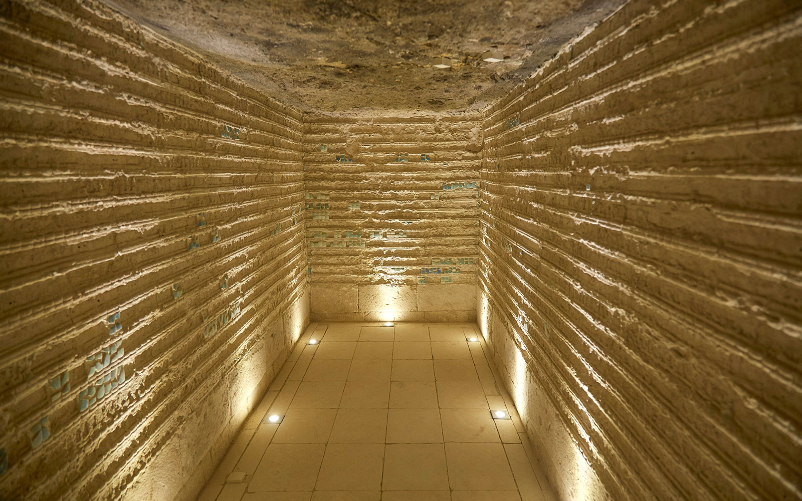 Corridor inside the Step Pyramid of Djoser, Saqqara, Egypt, with illuminated stone walls.