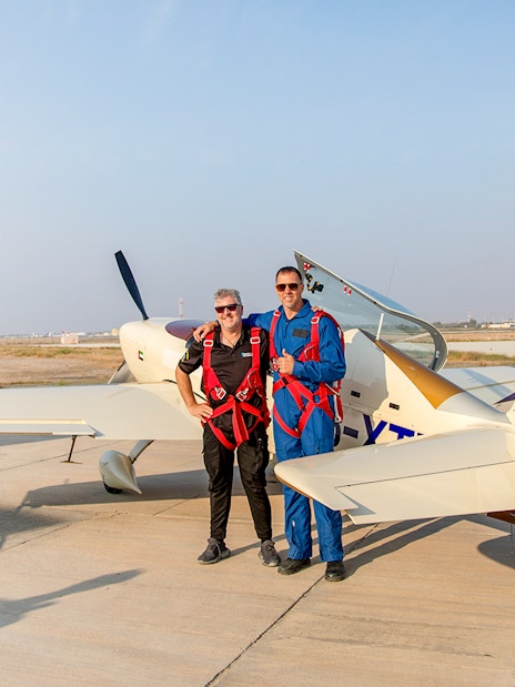 Pilot and passenger posing beside aerobatic plane after GFORCE Aerobatic Passenger Experience.