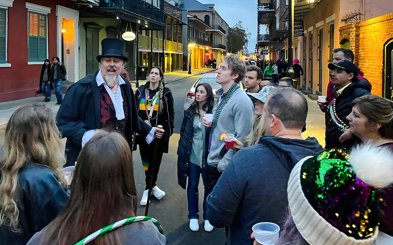 Guided tour group exploring haunted streets of New Orleans, featuring ghost, voodoo, and vampire lore.