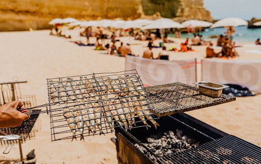 Grilled sardines on a beach barbecue during Albufeira cruise and beach BBQ.
