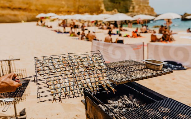 Grilled sardines on a beach barbecue during Albufeira cruise and beach BBQ.