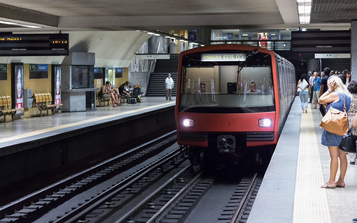 Lisbon Metro train arriving at a busy station platform, part of the Lisbon Card experience.