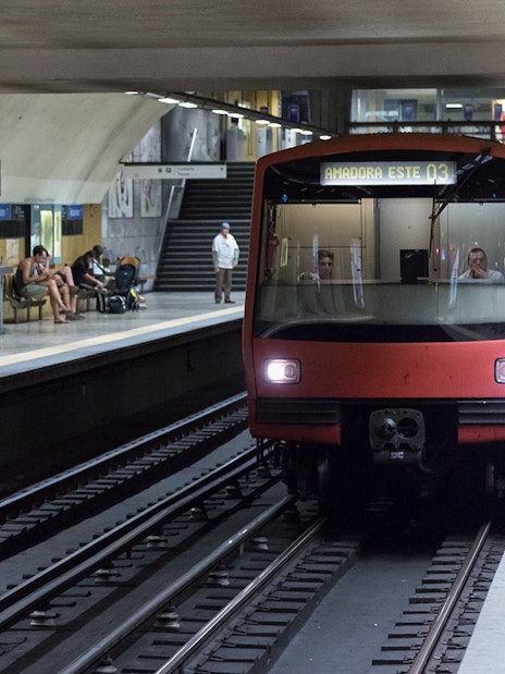 Lisbon Metro train arriving at a busy station platform, part of the Lisbon Card experience.