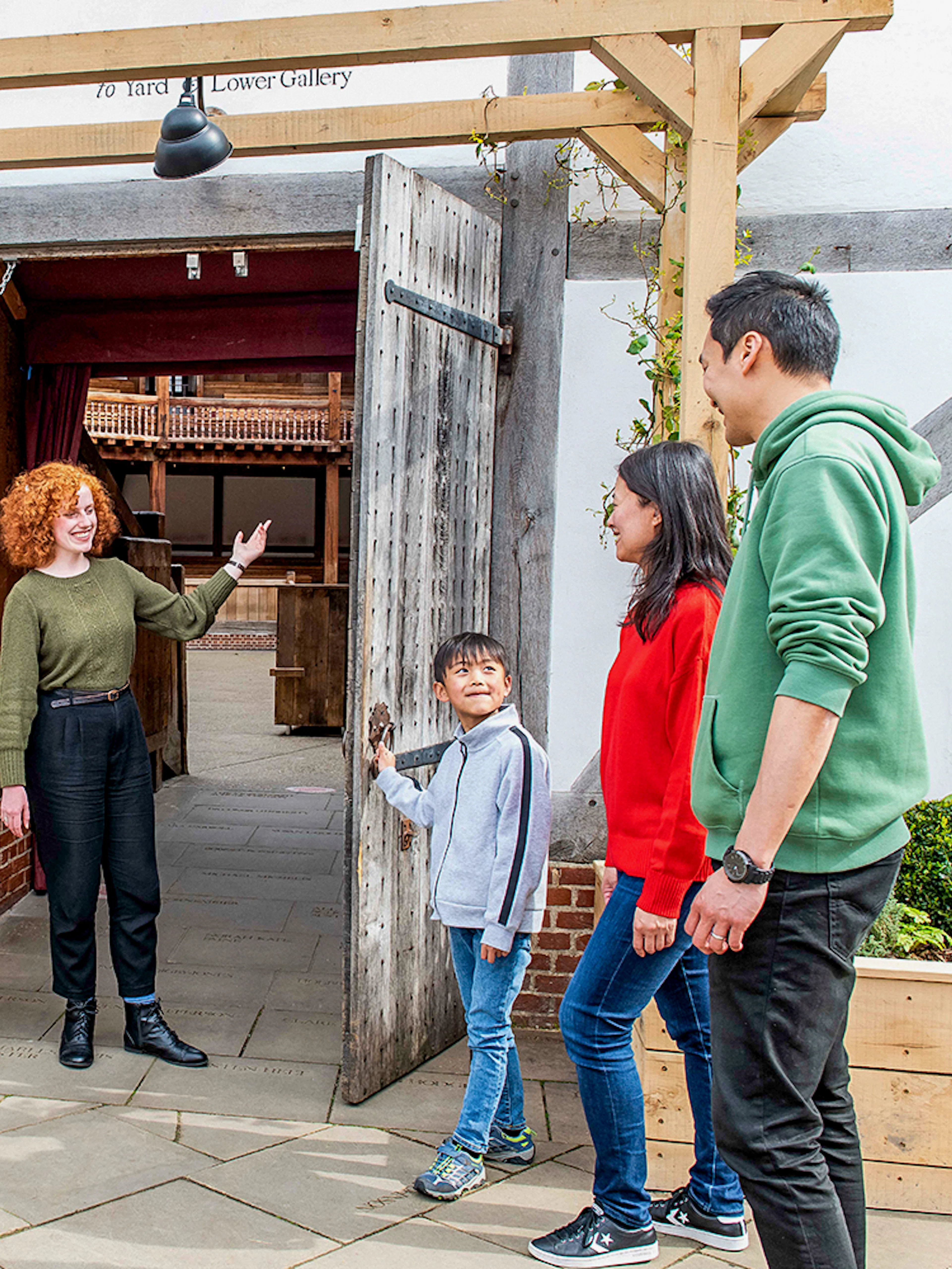 Visitors entering Shakespeare's Globe Theatre on a guided tour in London.