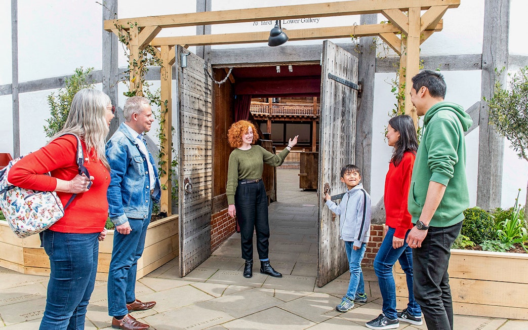 Visitors entering Shakespeare's Globe Theatre on a guided tour in London.