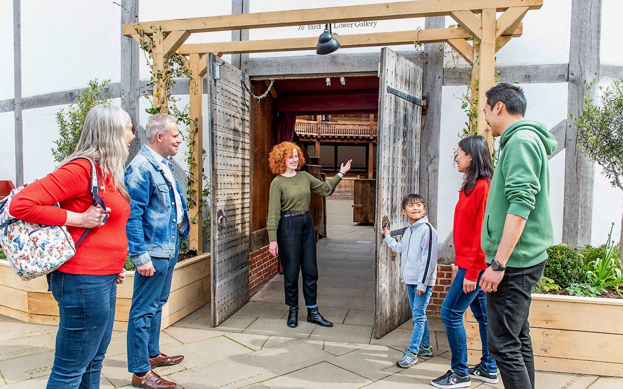 Visitors entering Shakespeare's Globe Theatre on a guided tour in London.