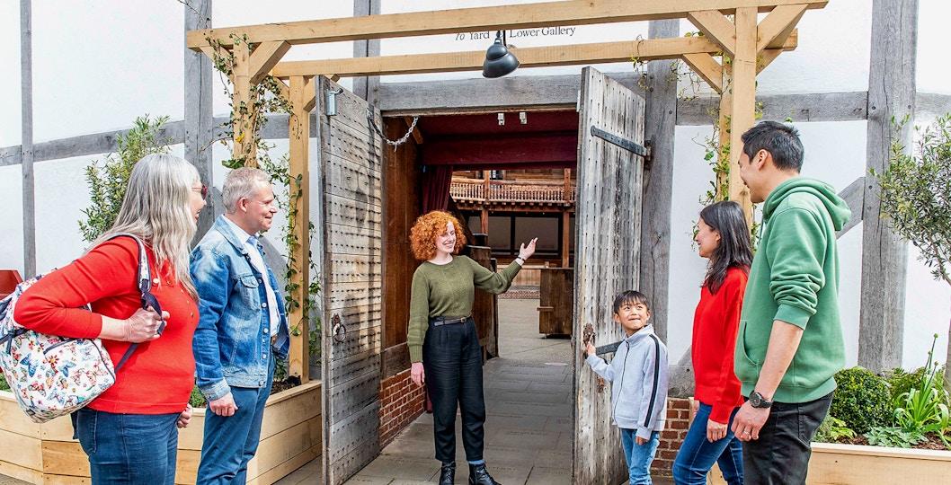 Visitors entering Shakespeare's Globe Theatre on a guided tour in London.