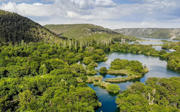 Aerial view of Krka River winding through lush greenery in Croatia.