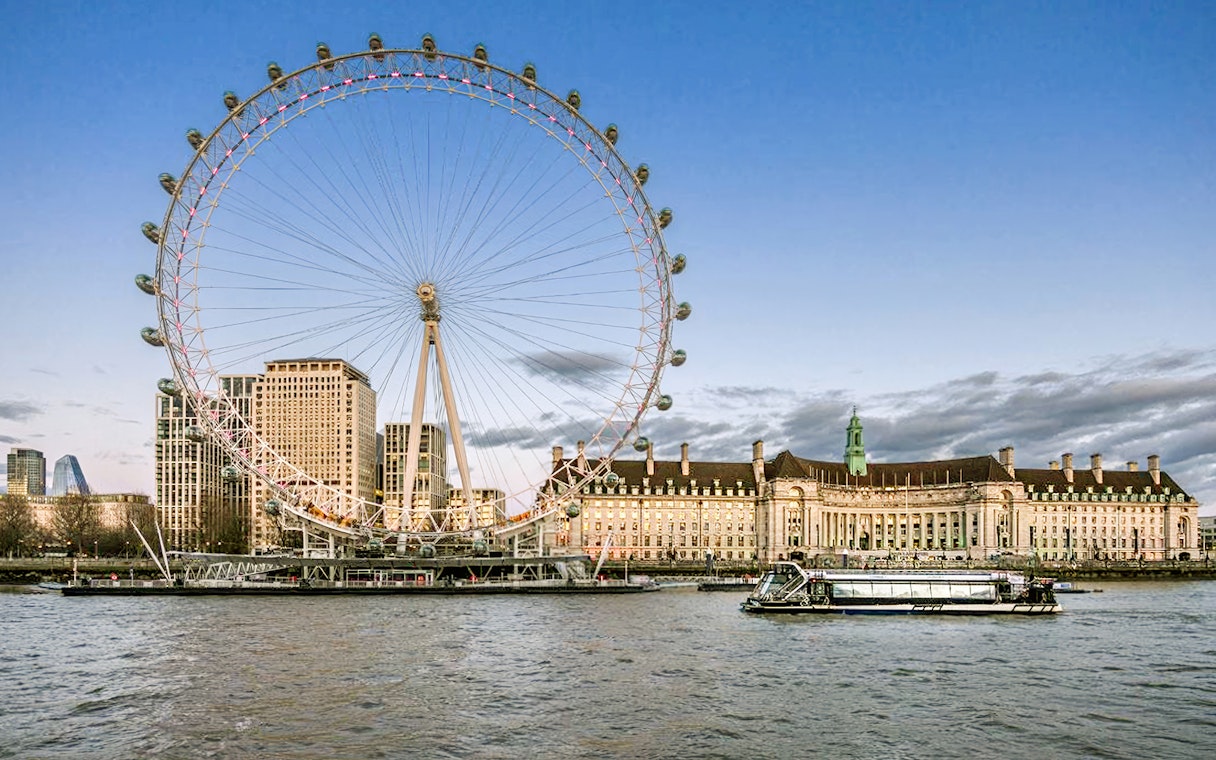 Evening cruise on the Thames with view of the London Eye and riverside buildings.