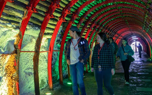 Tourists walking through illuminated tunnel to Zipaquira Salt Cathedral, Colombia.