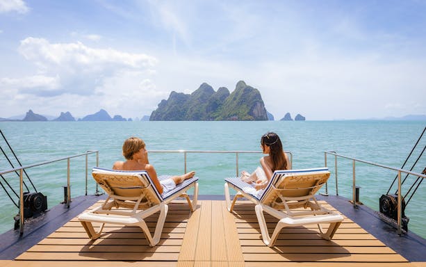 Guests relaxing on the deck of a cruise ship with ocean views, enhancing the travel experience.