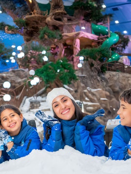 Family enjoying indoor snow park with treehouse and slides, part of Meal Deal experience.