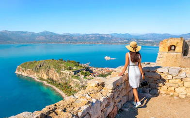 Tourist views Akronafplia Fortress and Palamidi Island from Palamidi Fortress, Nafplio, Greece.