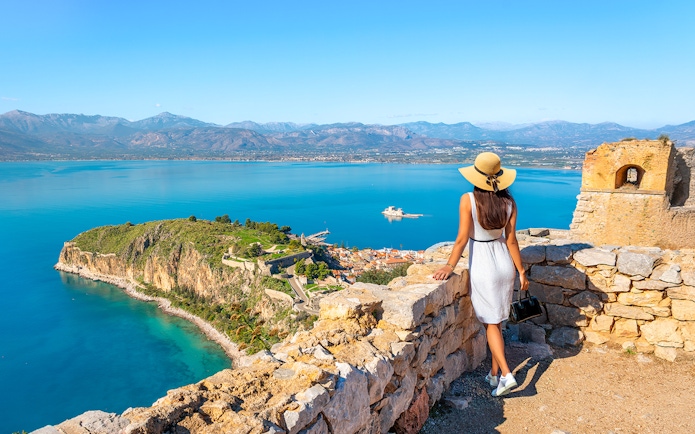 Tourist views Akronafplia Fortress and Palamidi Island from Palamidi Fortress, Nafplio, Greece.