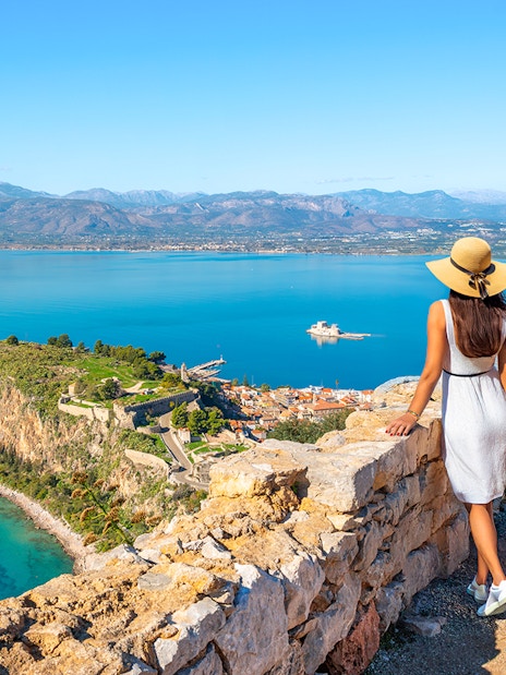 Tourist views Akronafplia Fortress and Palamidi Island from Palamidi Fortress, Nafplio, Greece.