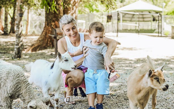 Mother and child petting goats at Maleny Botanic Gardens and Bird World.