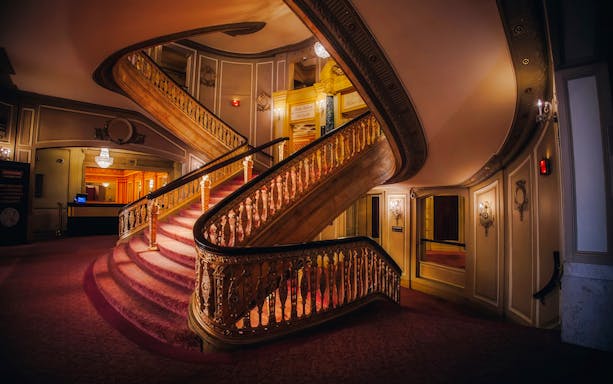 Grand staircase inside The Chicago Theatre with ornate railings and elegant decor.
