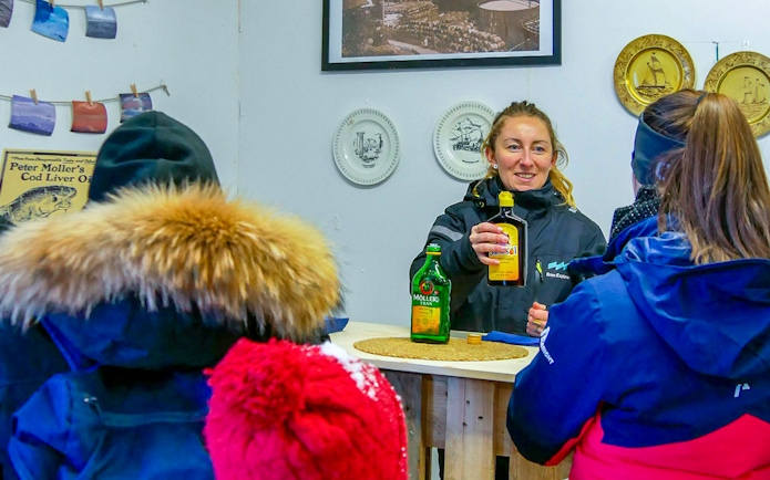 Local tasting experience with guide offering cod liver oil on Rya island.