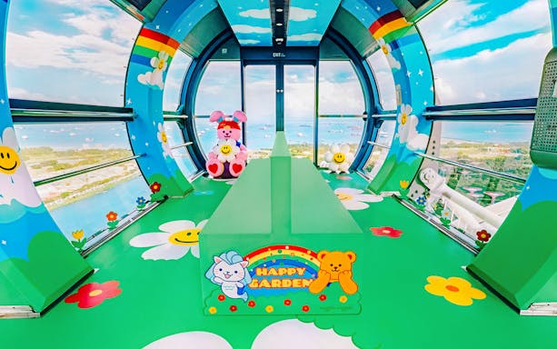 Singapore Flyer capsule interior with colorful cartoon decor and city view.