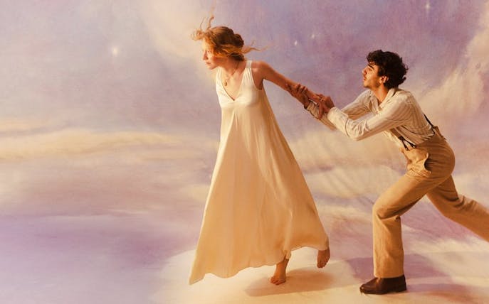 Two performers in a dramatic scene from La Bohème, with a dreamy backdrop.