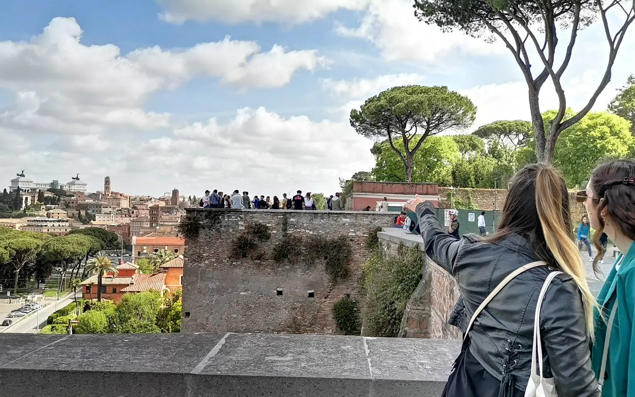 Tourists exploring Rome's landmarks from a viewpoint on a guided electric golf cart tour.