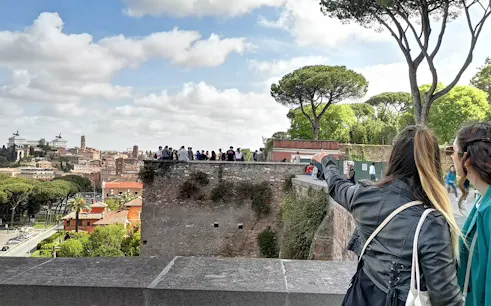 Tourists exploring Rome's landmarks from a viewpoint on a guided electric golf cart tour.