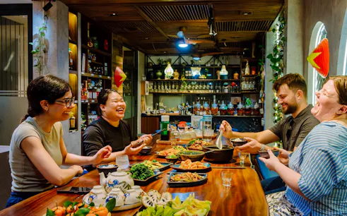 Guests enjoying a traditional meal at a private home dining experience in Hanoi.