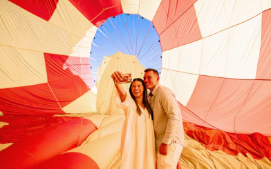 Couple taking a selfie inside a hot air balloon during Gold Coast Classic Ballooning tour.