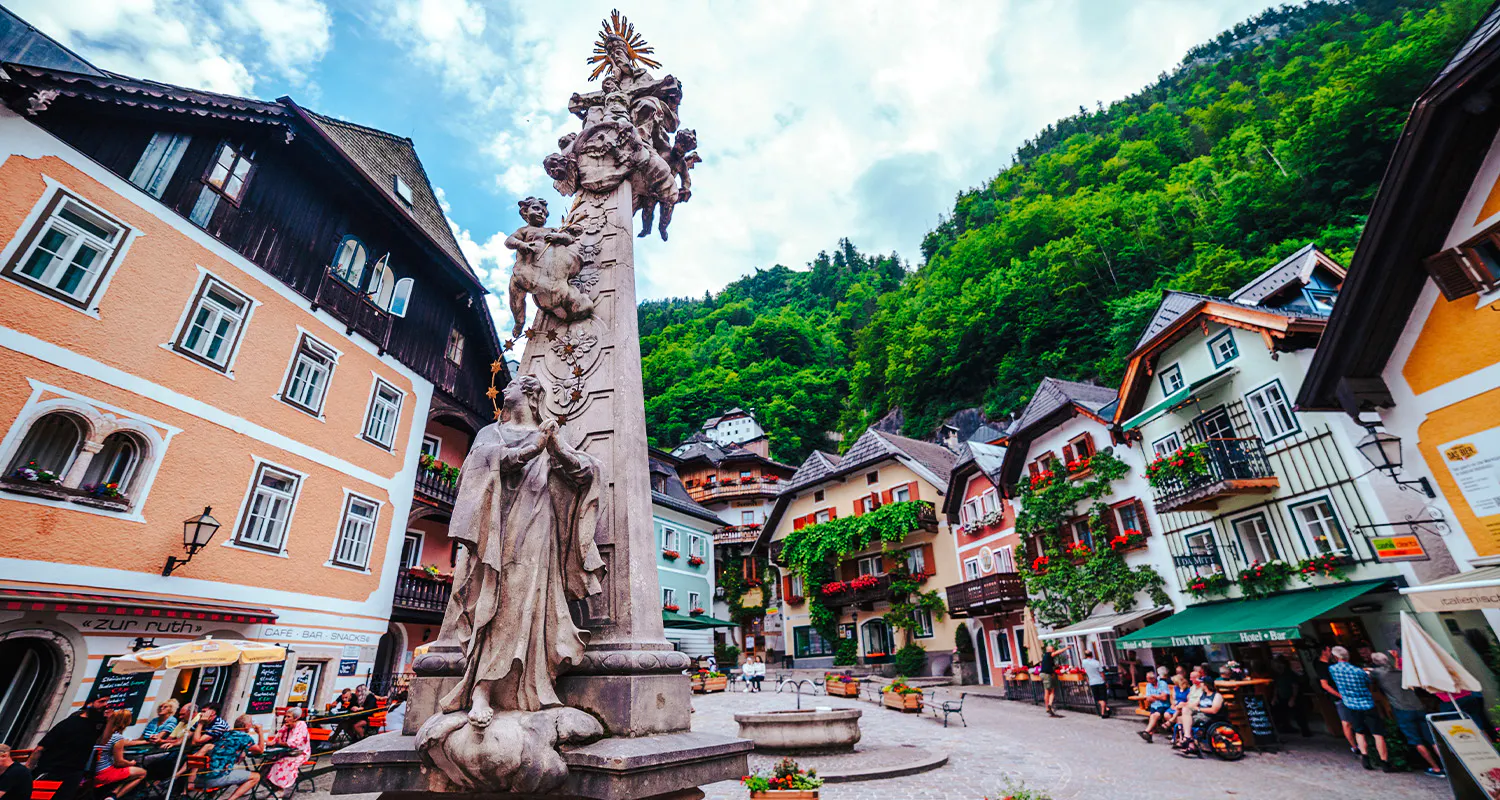 Hallstatt town square with historic buildings and statue, part of Vienna day trip.