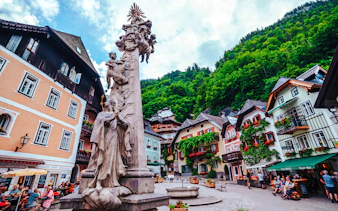 Hallstatt town square with historic buildings and statue, part of Vienna day trip.