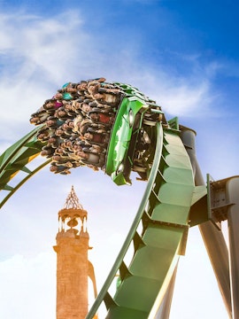 Guests on a rollercoaster with Islands of Adventure tower in background, Universal Studios Orlando.