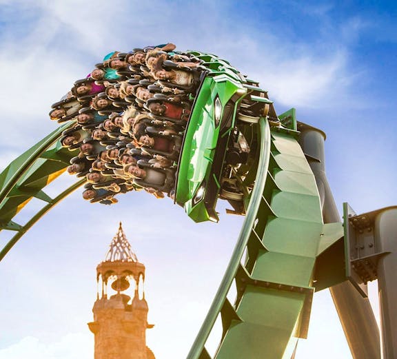 Guests on a rollercoaster with Islands of Adventure tower in background, Universal Studios Orlando.