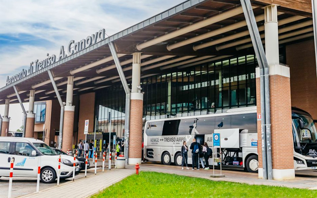 Treviso Airport bus station with passengers boarding a bus to Venice.