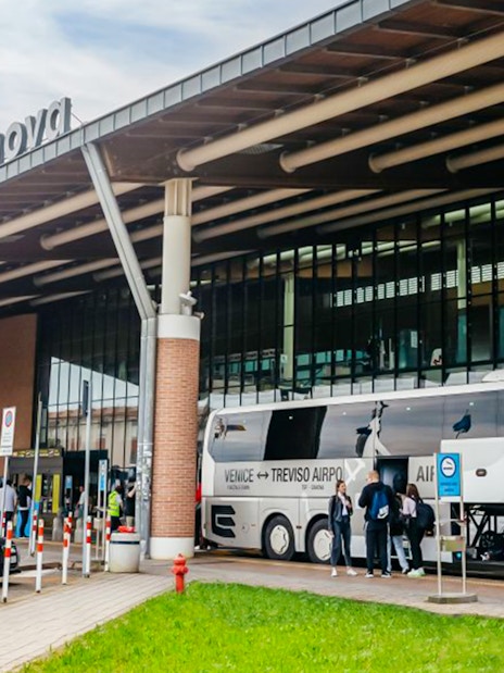 Treviso Airport bus station with passengers boarding a bus to Venice.