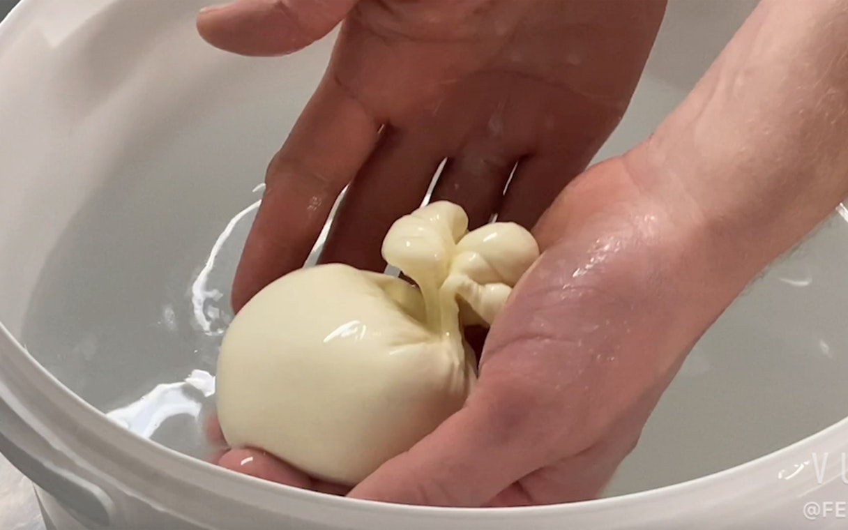 Person crafting burrata cheese at Cheese Museum, Paris, France.