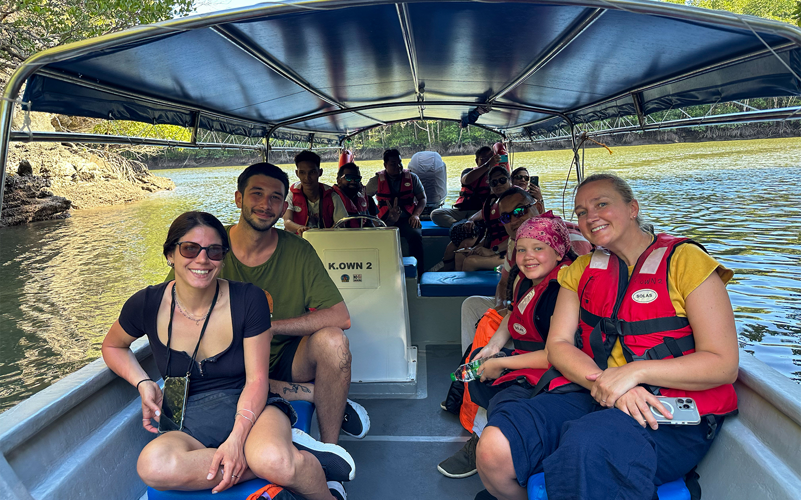 Passengers in life vests on a boat during Langkawi mangrove tour.