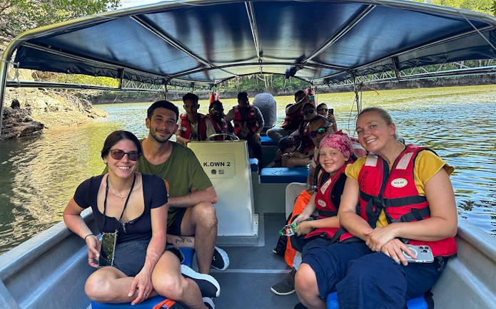 Passengers in life vests on a boat during Langkawi mangrove tour.